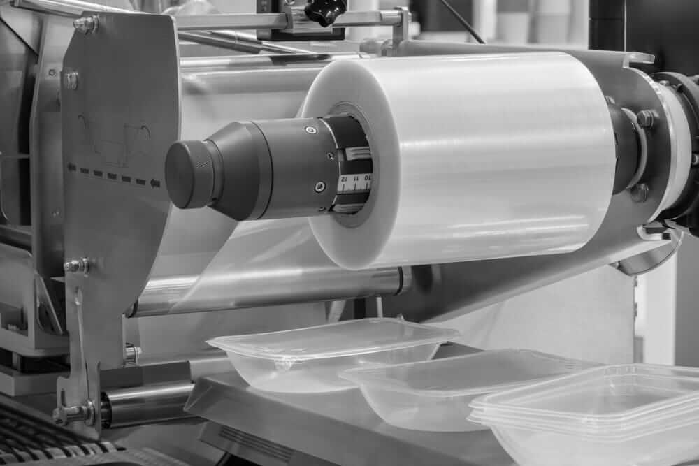 Rolka taśmy foliowej z recyklingu w maszynie pakującej na linii produkcyjnej – gralapack.com.pl