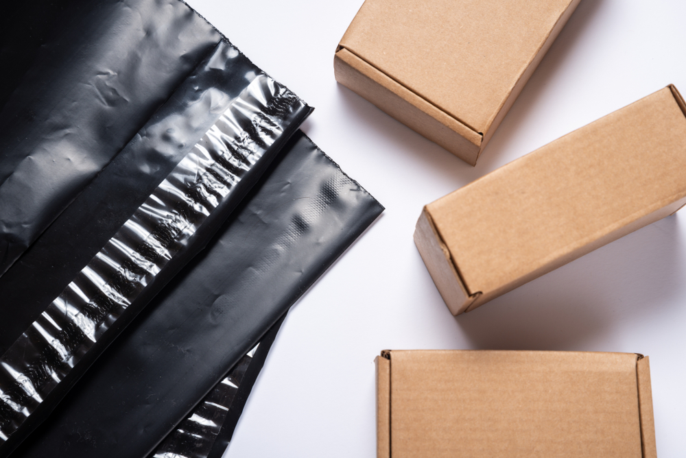 Czarne foliopaki kurierskie leżące obok niewielkich pudełek - /gralapack.com/pl/