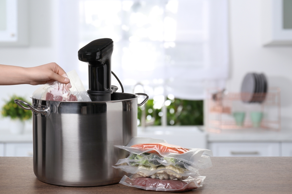 Kobieta umieszczająca produkty spożywcze w urządzeniu do gotowania metodą sous vide - /gralapack.com/pl/